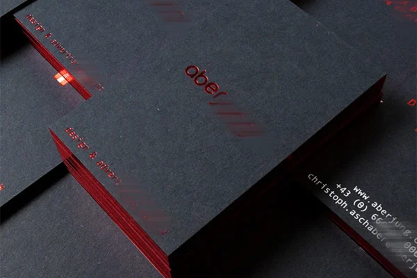 Luxury black business card with red edges and hot stamp design for enterprises.