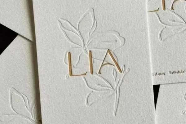 Embossed business card with floral design for luxury branding.
