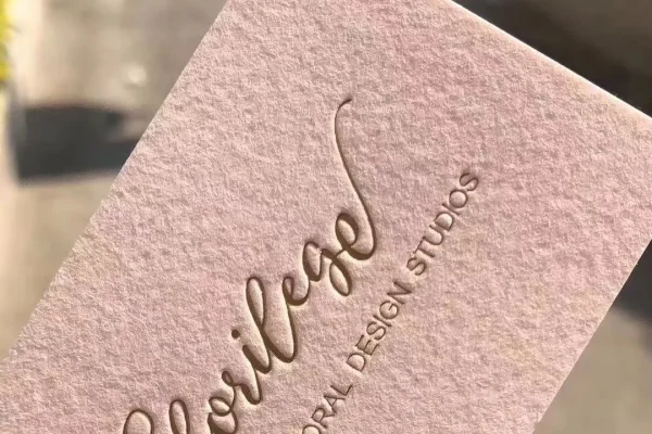 Embossed business card with floral design, showcasing luxury printing.