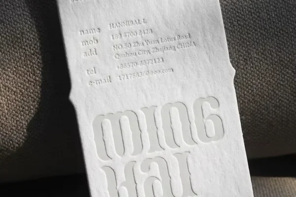 Embossed business card with custom logo and contact details.