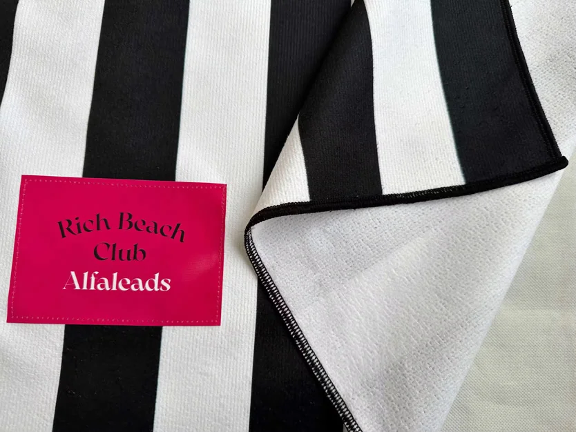 Custom towel with black and white stripes and pink label for custom towel service.